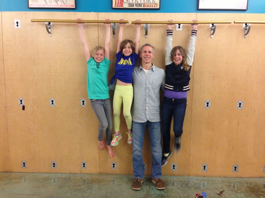 Ben Gordon with his kids hanging from Castle Hill ballet barres