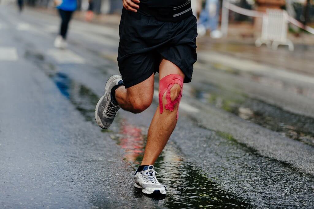 Man with Kinesiotape on Knee Running