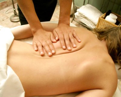 Therapist working on a woman's back during a massages session