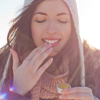 Girl applying lip balm in a cold climate