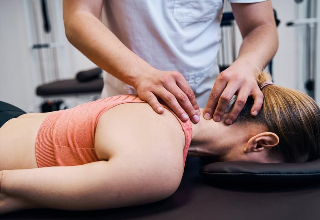 Image of person performing Active Release Techniques on woman lying face down on massage bed.