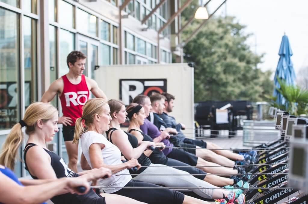 People exercising on rowing machines to announce Rō fitness classes