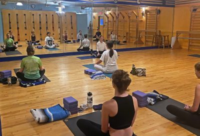 People sitting and meditating in a yoga class