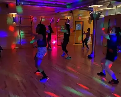 Image of a dance class in a colorfully lit studio